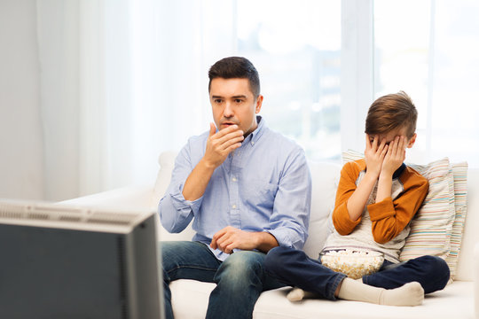 Father And Son Watching Horror Movie On Tv At Home