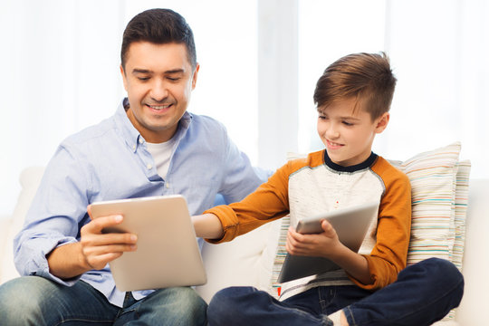 happy father and son with tablet pc at home