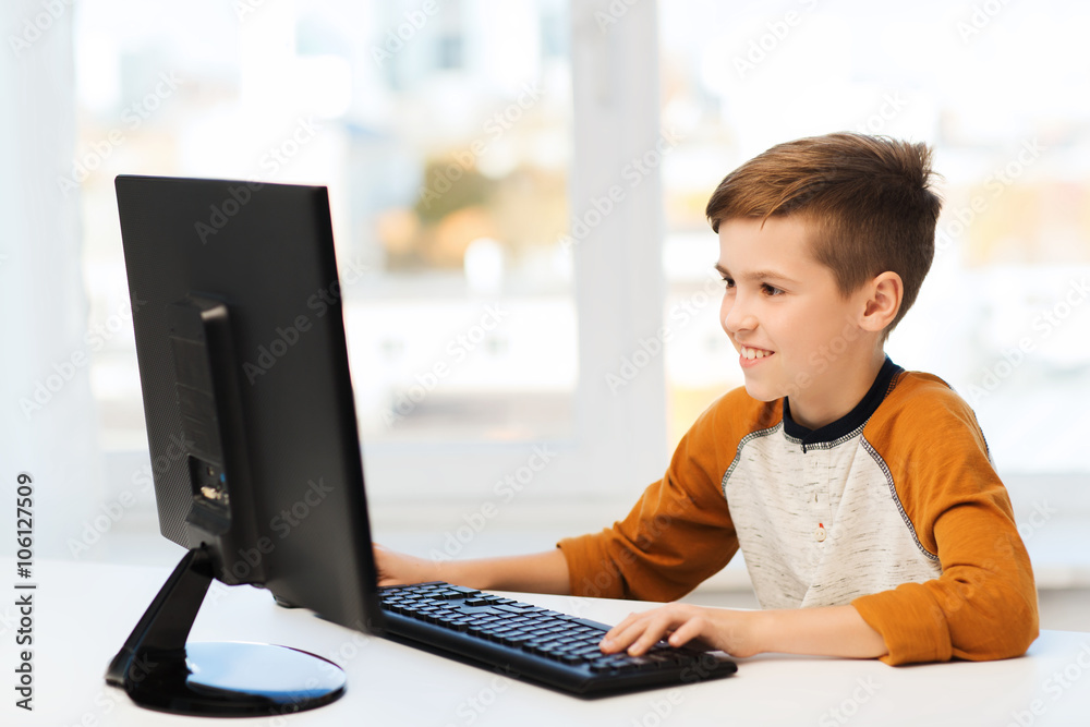 Wall mural smiling boy with computer at home