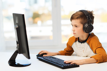 boy with computer and headphones at home © Syda Productions