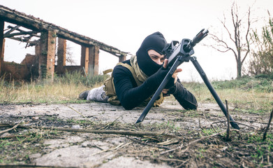 Man aiming rifle while lying outdoors