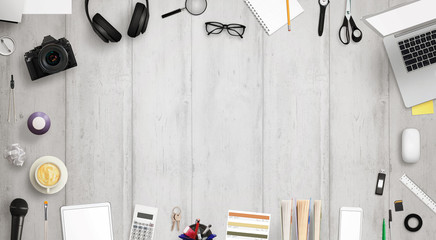 Work desk with free space for text surrounded with a lot of desk accessories. There is a laptop, tablet, phone, camera, headset, mouse, glasses, camera, pens, paper... © Stanisic Vladimir