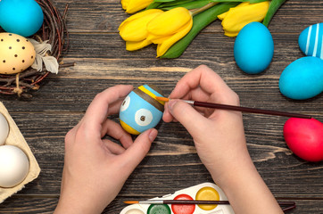 Girl's hand painting Easter eggs