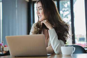 Businesswoman drinking coffee / tea and using tablet computer in