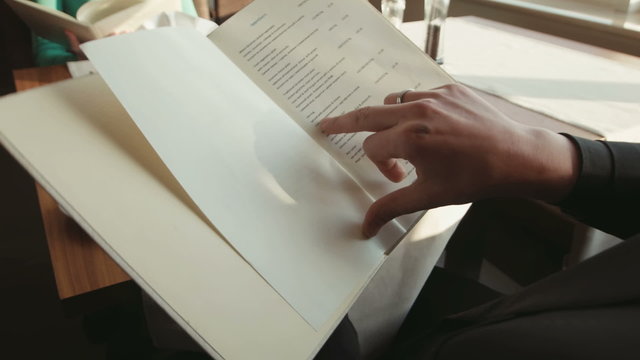 The man watches the menu at restaurant of hotel