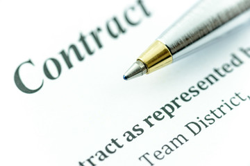 Obraz premium Blue ballpoint pen on a contract, ready to sign and fill a form.