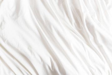 Top view of wrinkles on an unmade bed sheet after waking up in the morning.