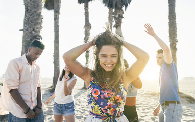 Group of friends making party on the beach and dancing together