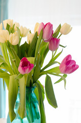 Bouquet of beautiful pink and yellow tulips in tiffany vase.