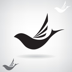 Stylized black silhouette of a flying bird. 