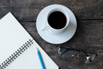 still life with White cup of hot coffee , white notebook ,pencil