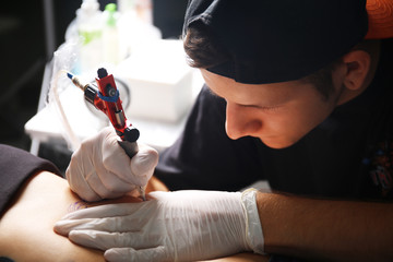 Tattooist makes tattoo, close up