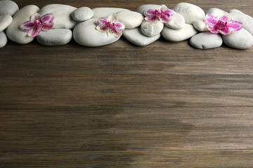 Fototapeta na wymiar Spa stones and orchid on wooden background