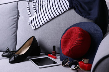 Composition of woman's fashion look on a gray couch