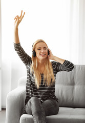 Obraz premium Young woman sitting and listening to music in a room
