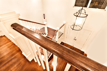 View of glossy wooden stairs from top showing the closed door