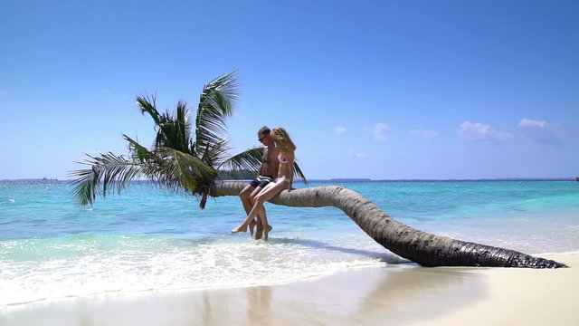 A loving couple enjoying vacation on a tropical beach. Slow Motion.