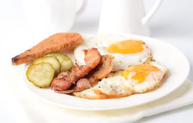 fried eggs with bacon and toasts on white background
