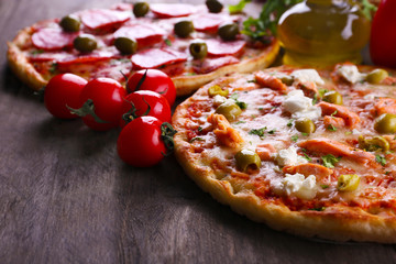 Delicious tasty pizzas with ingredients on table, closeup