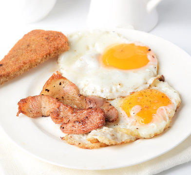 Ried Eggs With Bacon And Toasts On White Background
