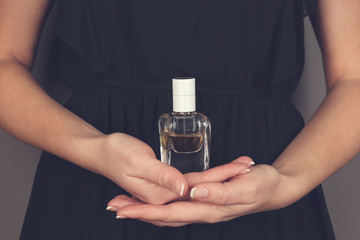 Fototapeta premium Young woman holding bottle perfume