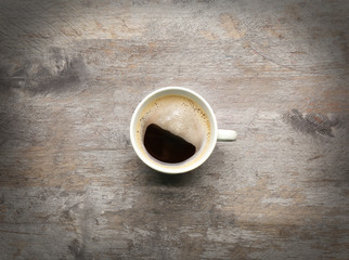 Cup of coffee on wooden table, top view