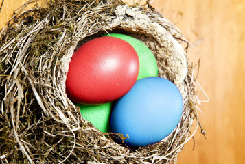 red, blue and green Easter eggs in a nest