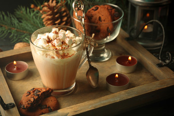 Cup of hot cacao with marshmallow and cookies on black table