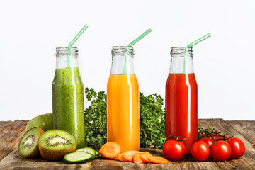 The bottles with fresh vegetable juices on wooden table