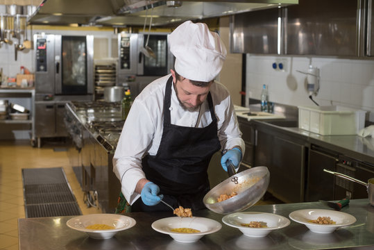 chef prepares dishes of risotto with prawns