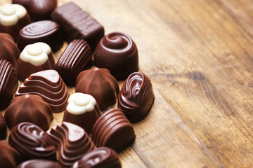 Delicious chocolate candies on wooden background