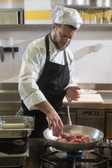 chef cooking pork tenderloin in a pan