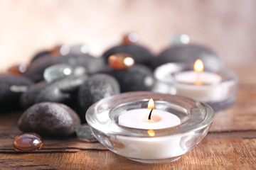 Spa still life with stones and candlelight on blurred pastel background