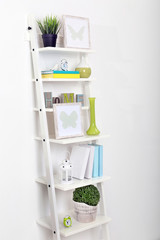 Fototapeta na wymiar White bookcase with books and accessories in the room