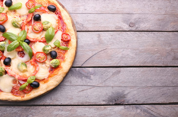 Delicious pizza with cheese and vegetables on wooden background