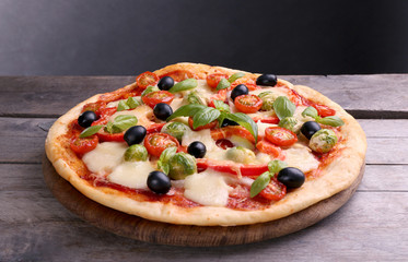Delicious pizza with cheese and vegetables on grey background