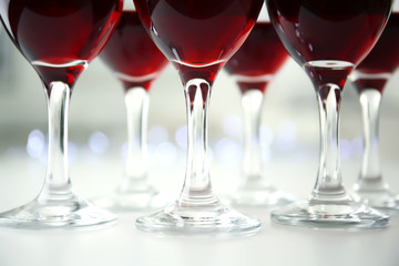 Glasses of red wine on white table closeup