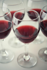 Glasses of red wine on white table closeup