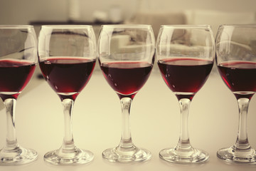 Glasses of red wine on white table closeup