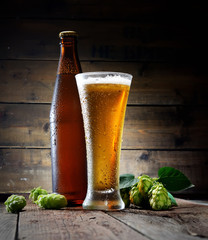 beer, bottle and hop on a wooden background
