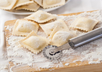 Fototapeta na wymiar Making homemade Italian pasta ravioli with a cutting tool