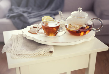 Tea set with hot tea and breakfast on a white wooden mat on the table