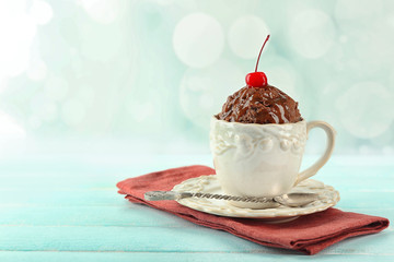 Chocolate mug cake with cream and cherry on napkin on table
