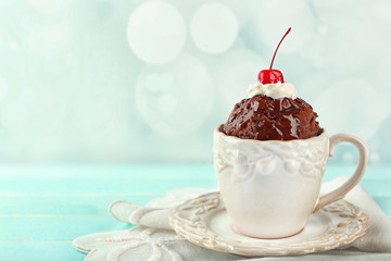 Chocolate mug cake with cream and cherry on a table