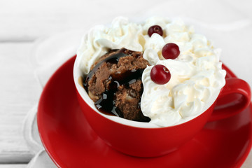 Chocolate mug cake with cream and cranberry on a white napkin