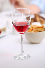 Dinner with glass of wine on table closeup