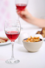 Dinner with glasses of wine on light blurred background