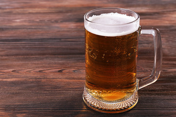 Glass of beer on wooden background