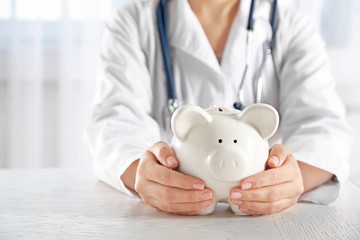 Doctor hands with piggy bank closeup