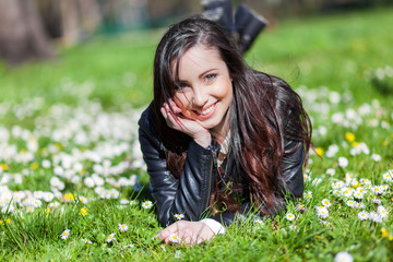 Young beautiful woman lying on the grass and smiling